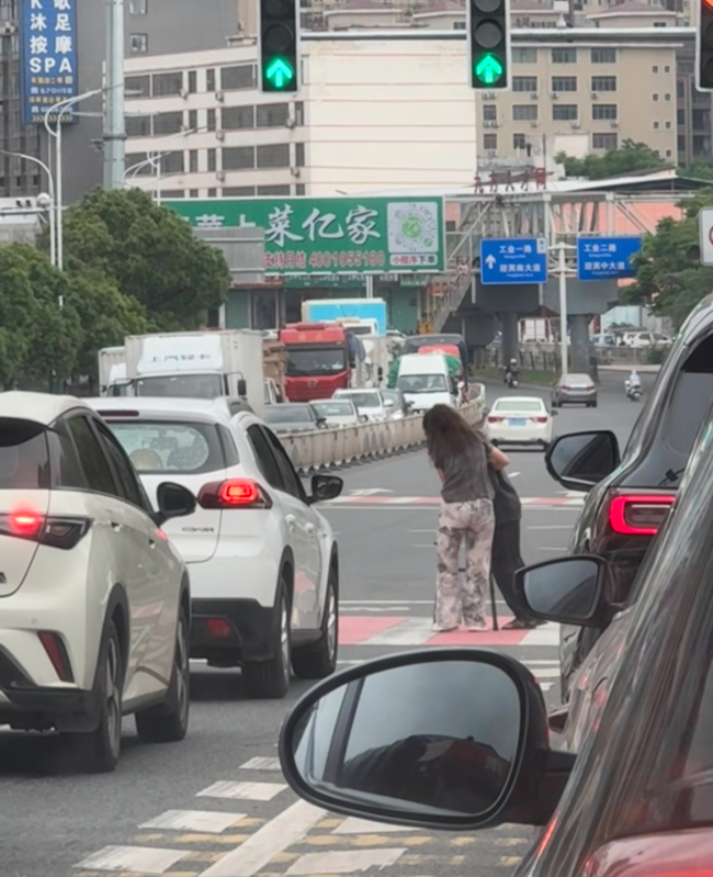 女子扶老人过马路车辆让行