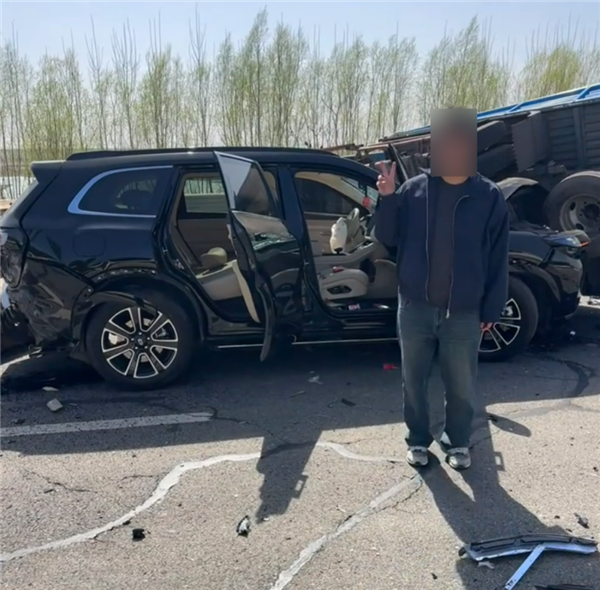 问界M7撞上满载木头货车 车主毫发无伤：淡定与车合影