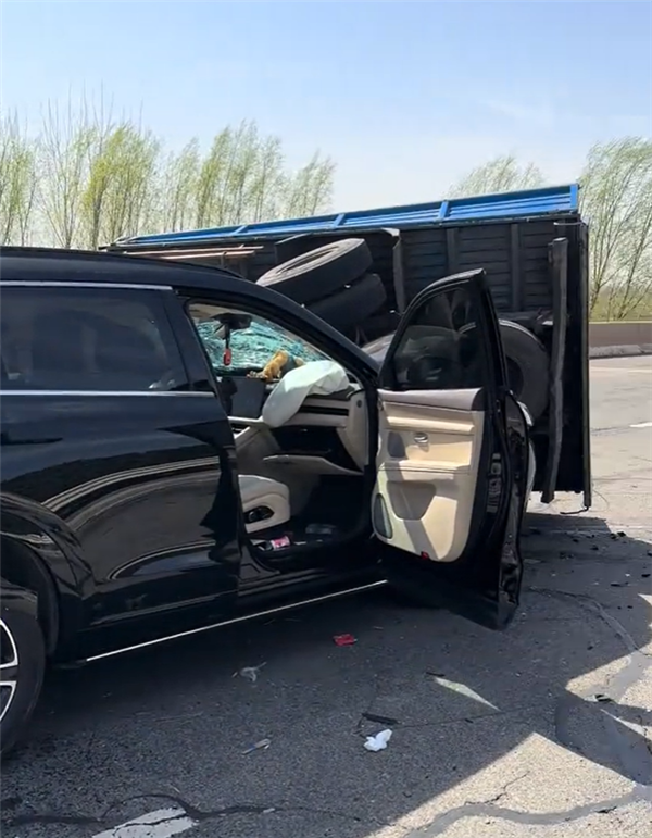 问界M7撞上满载木头货车 车主毫发无伤：淡定与车合影